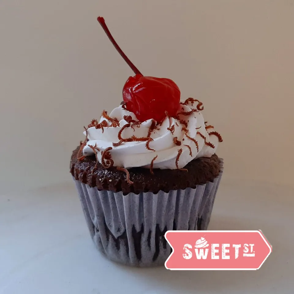 Cupcake de chocolate con crema y una cereza