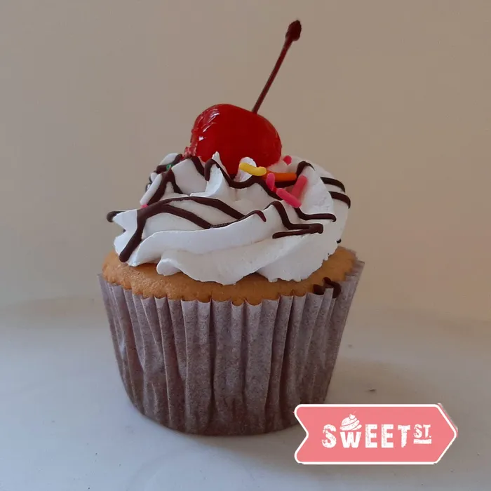 Cupcake Banana Split con crema, salsa de chocolate y una cereza