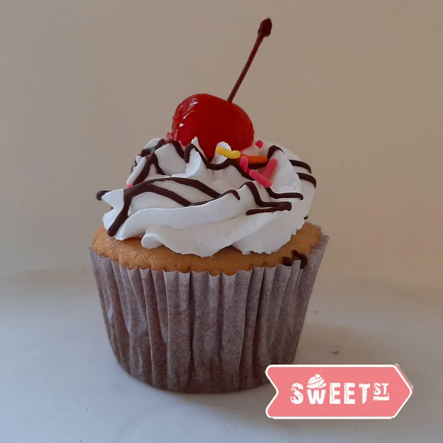 Cupcake Banana Split decorado con crema y una cereza